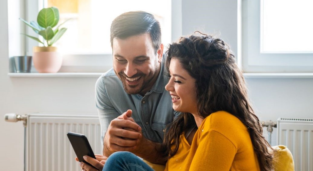 Young couple viewing and entering data on mobile phone