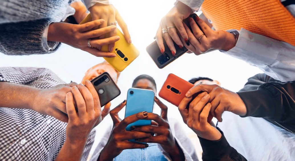 Adults in circle holding smart mobile phones